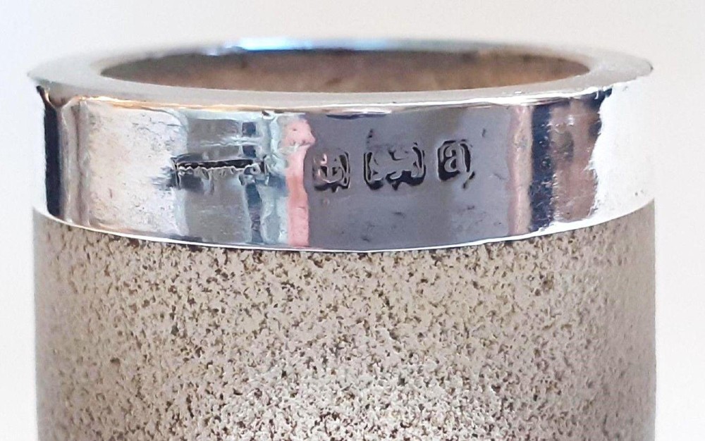 A clear glass match striker shaped like a boot with a textured band on the collar and a polished silver rim. View VI