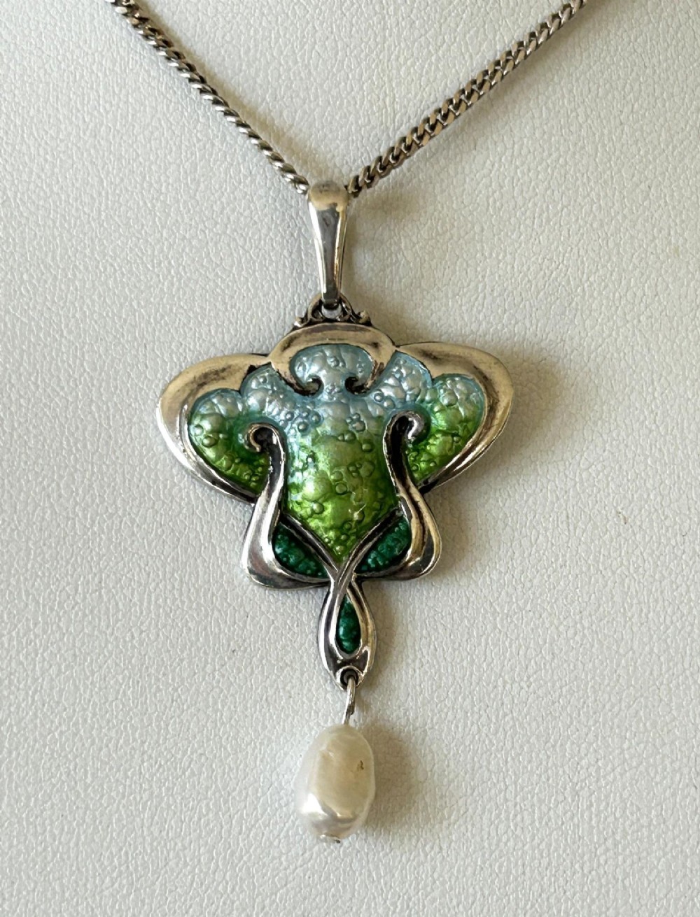 An Art Nouveau silver pendant necklace featuring green and blue enamel in an organic shape with a suspended pearl drop. View VII