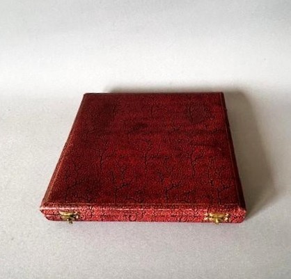 A set of four silver crab picks arranged inside a navy velvet and white silk lined burgundy presentation box. View VI