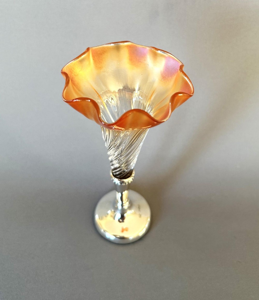 An Edwardian posy vase featuring a wrythen glass trumpet with a flared orange rim, set into a silver pedestal base. View V
