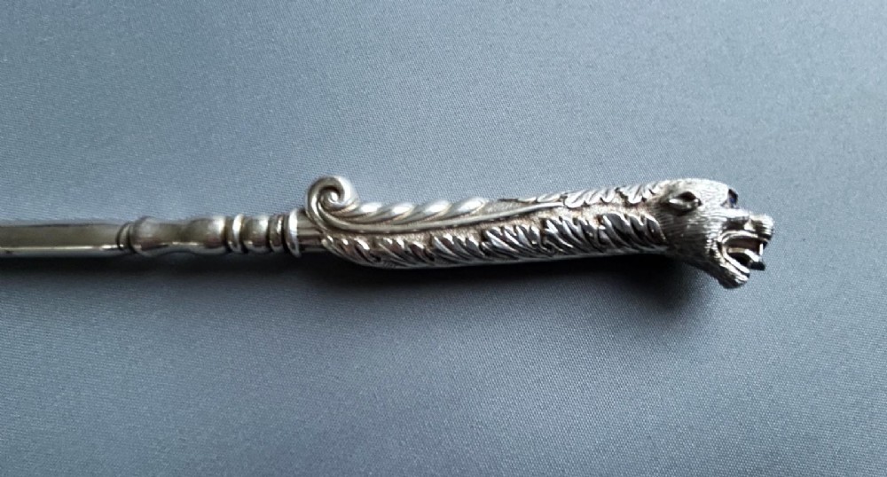 A Victorian silver toasting fork featuring a three-tined head with a pierced trefoil design, a slender stem, and a handle sculpted as a panther head. View II