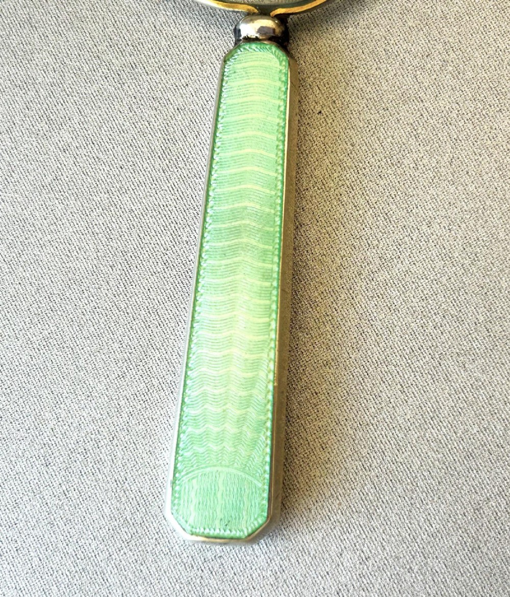 An Art Deco magnifying glass featuring a round glass lens set in a silver frame with an elongated mint green guilloche enamel handle. View IV