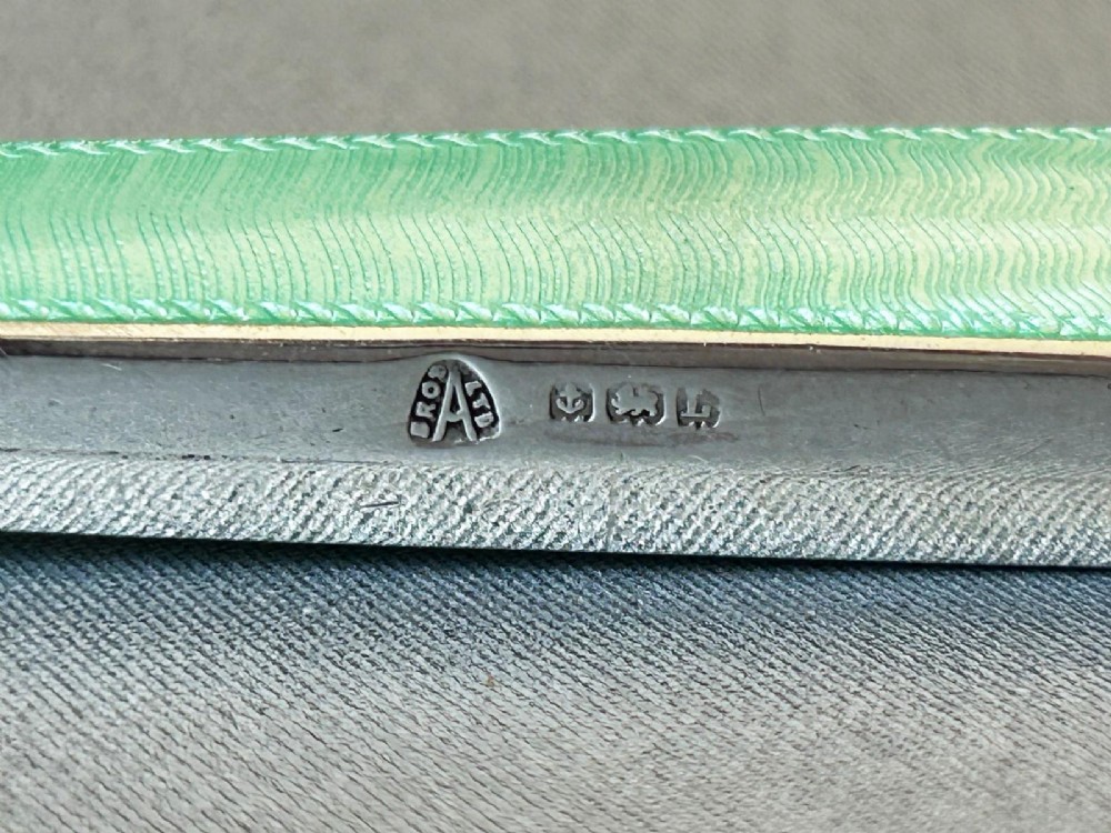 An Art Deco magnifying glass featuring a round glass lens set in a silver frame with an elongated mint green guilloche enamel handle. View V