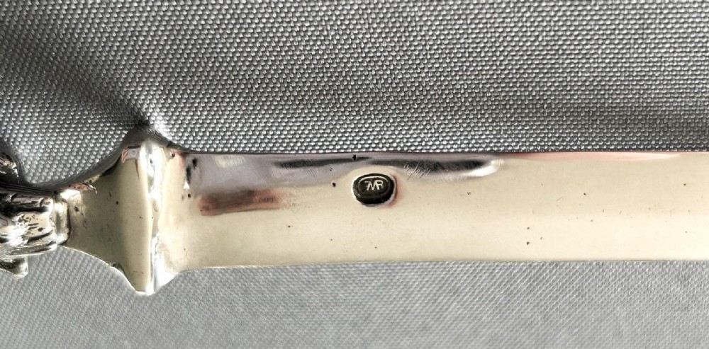 A silver letter opener featuring a finely cast owl handle above a polished blade engraved with script text. View IV