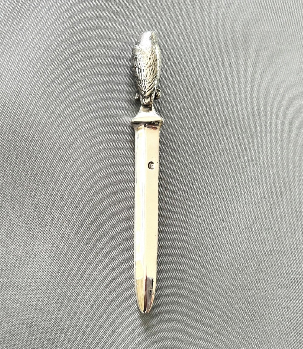 A silver letter opener featuring a finely cast owl handle above a polished blade engraved with script text. View V
