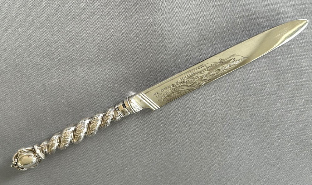 A Victorian silver fish serving knife featuring an engraved river landscape scene on the blade and a chased spiral twist handle. View III