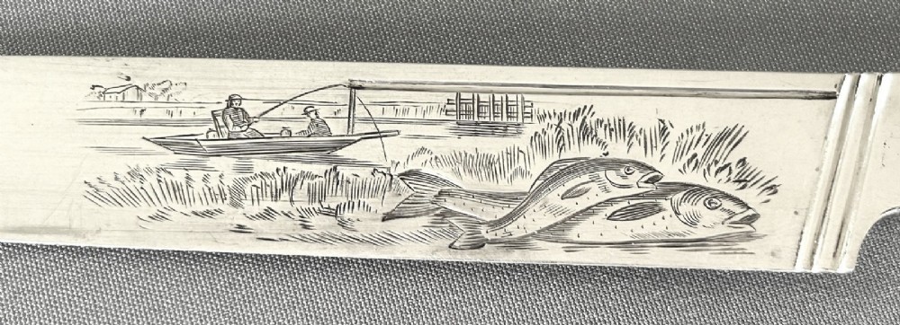 A Victorian silver fish serving knife featuring an engraved river landscape scene on the blade and a chased spiral twist handle. View VI