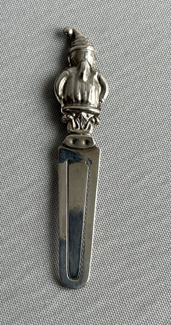A solid silver bookmark featuring a cast figural handle of Mr. Punch above a flat clip section stamped with Scottish hallmarks. View V