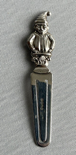 A solid silver bookmark featuring a cast figural handle of Mr. Punch above a flat clip section stamped with Scottish hallmarks. View VI