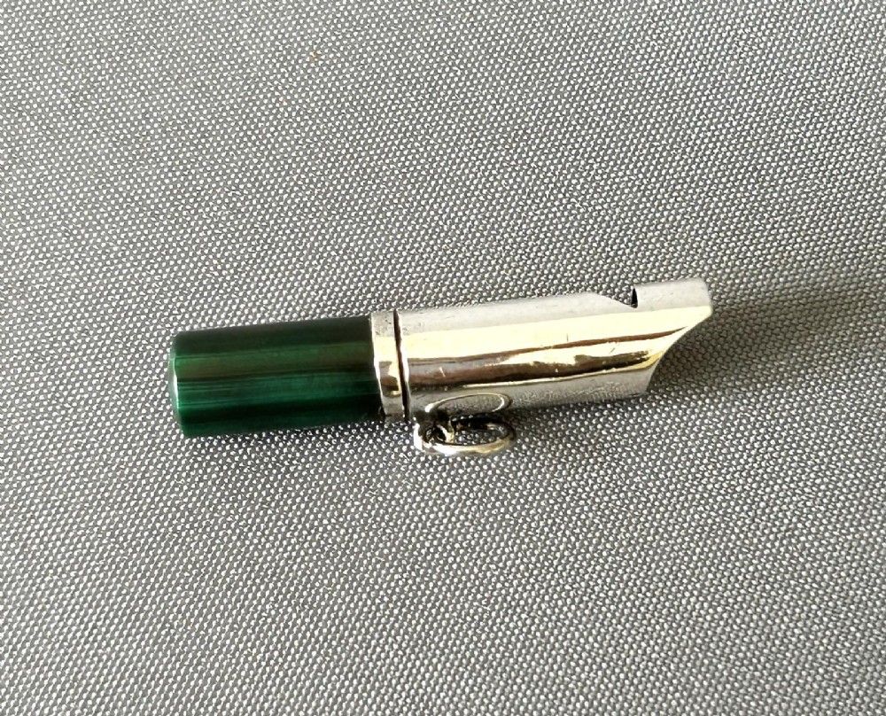 A Victorian silver whistle with a cylindrical polished green malachite handle and a silver suspension ring.