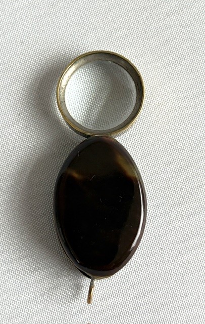 A Victorian oval dark brown tortoiseshell folding loupe decorated with silver pique foliate inlay and featuring a swivelling circular magnifying glass lens. View V