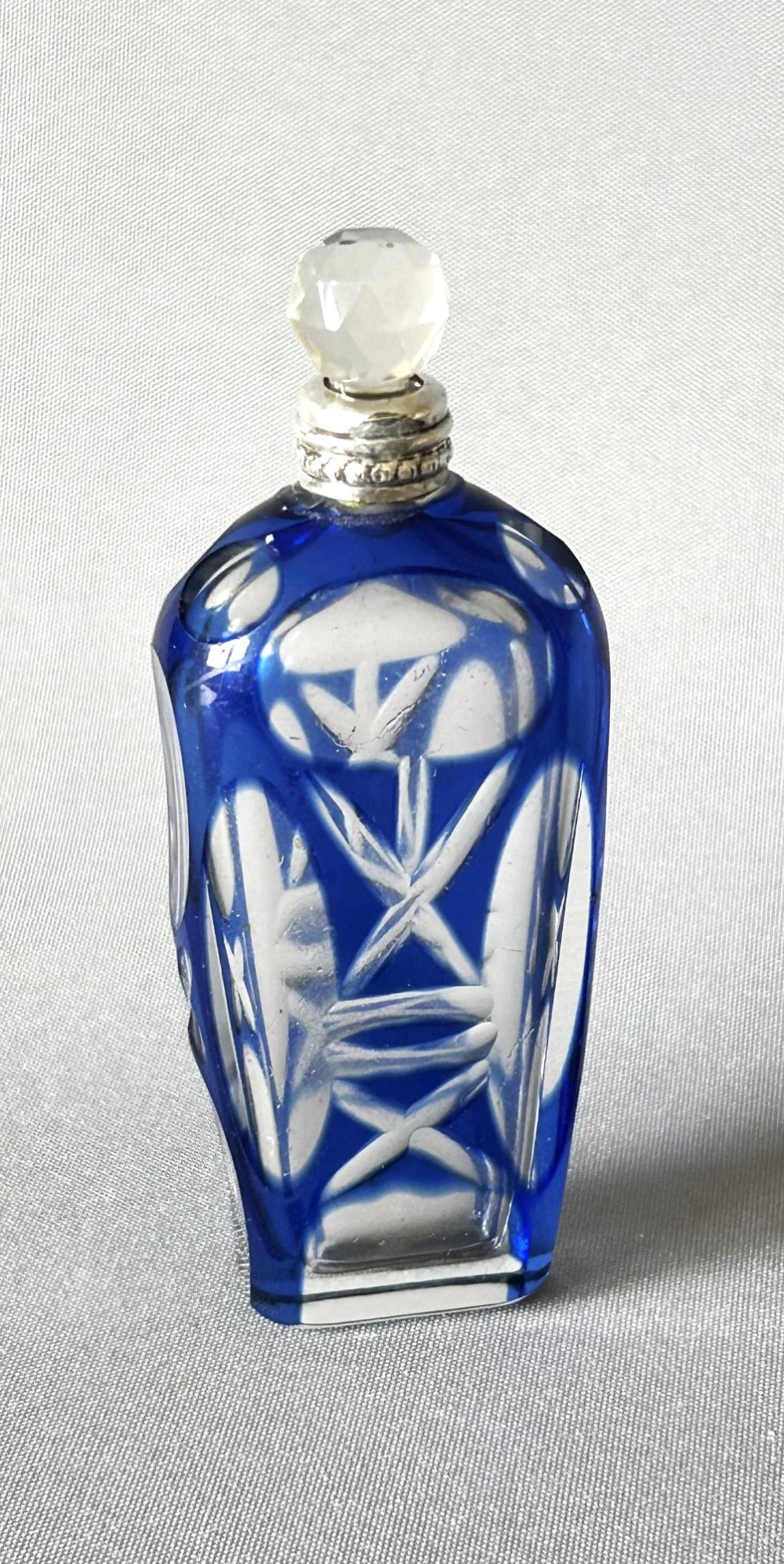 A Victorian cobalt blue cut-to-clear glass scent flask featuring a silver collar and a faceted clear glass stopper.