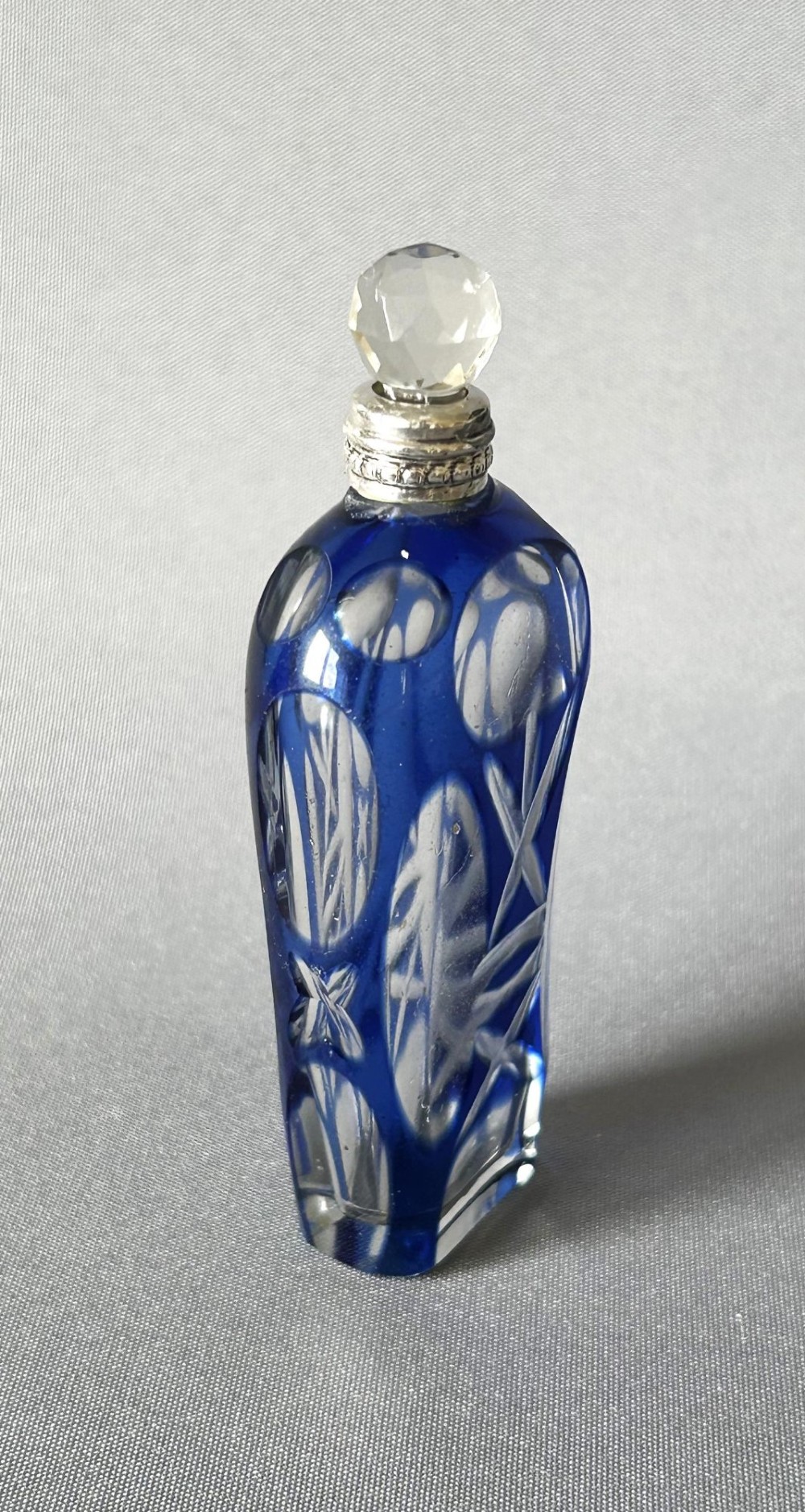 A Victorian cobalt blue cut-to-clear glass scent flask featuring a silver collar and a faceted clear glass stopper. View III
