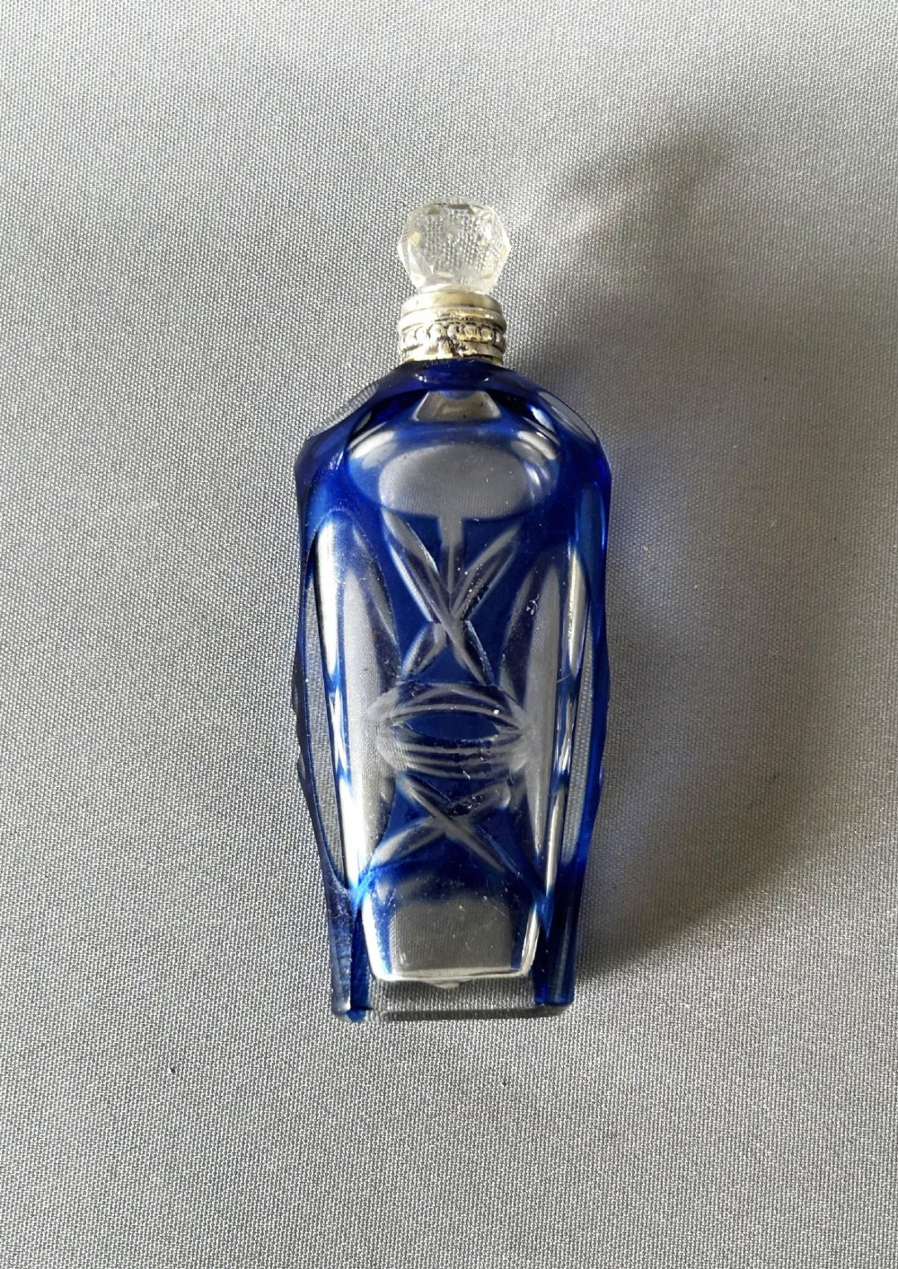 A Victorian cobalt blue cut-to-clear glass scent flask featuring a silver collar and a faceted clear glass stopper. View VI