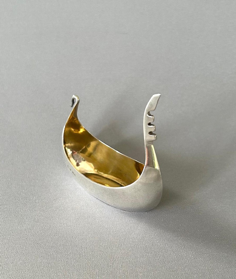 A Victorian sterling silver salt tub fashioned in the shape of a boat with a gilded interior and visible hallmarks on the exterior side. View IV