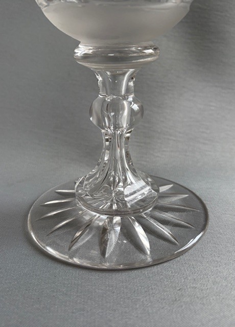 A clear Victorian cut crystal wine goblet featuring a frosted geometric pattern, faceted stem, and star-cut base. View IV