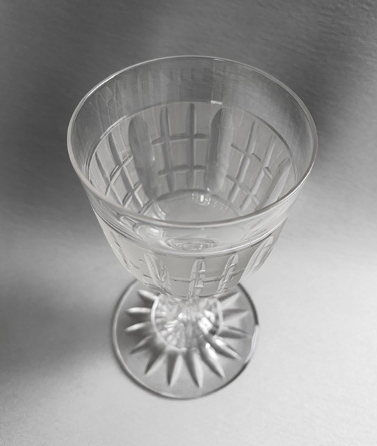 A clear Victorian cut crystal wine goblet featuring a frosted geometric pattern, faceted stem, and star-cut base. View V