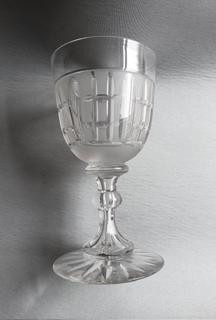 A clear Victorian cut crystal wine goblet featuring a frosted geometric pattern, faceted stem, and star-cut base. View VII