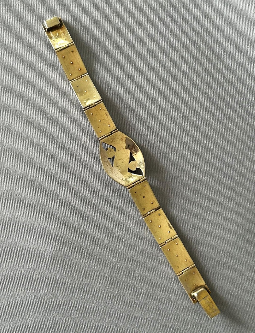 An Art Deco silver gilt panel link bracelet featuring geometric leaf motifs inlaid with small cut paste stones. View II