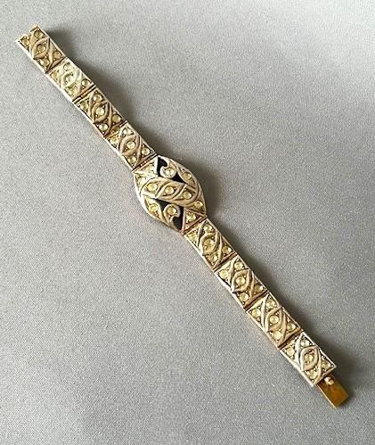 An Art Deco silver gilt panel link bracelet featuring geometric leaf motifs inlaid with small cut paste stones. View V