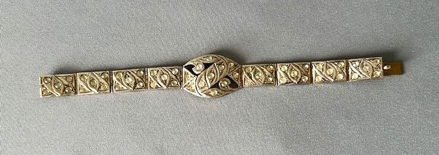 An Art Deco silver gilt panel link bracelet featuring geometric leaf motifs inlaid with small cut paste stones. View VI