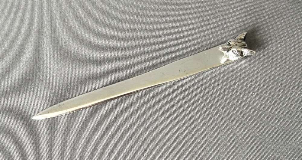 A silver letter opener featuring a tapered flat blade and a detailed cast fox head terminal. View III