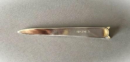 A silver letter opener featuring a tapered flat blade and a detailed cast fox head terminal. View V