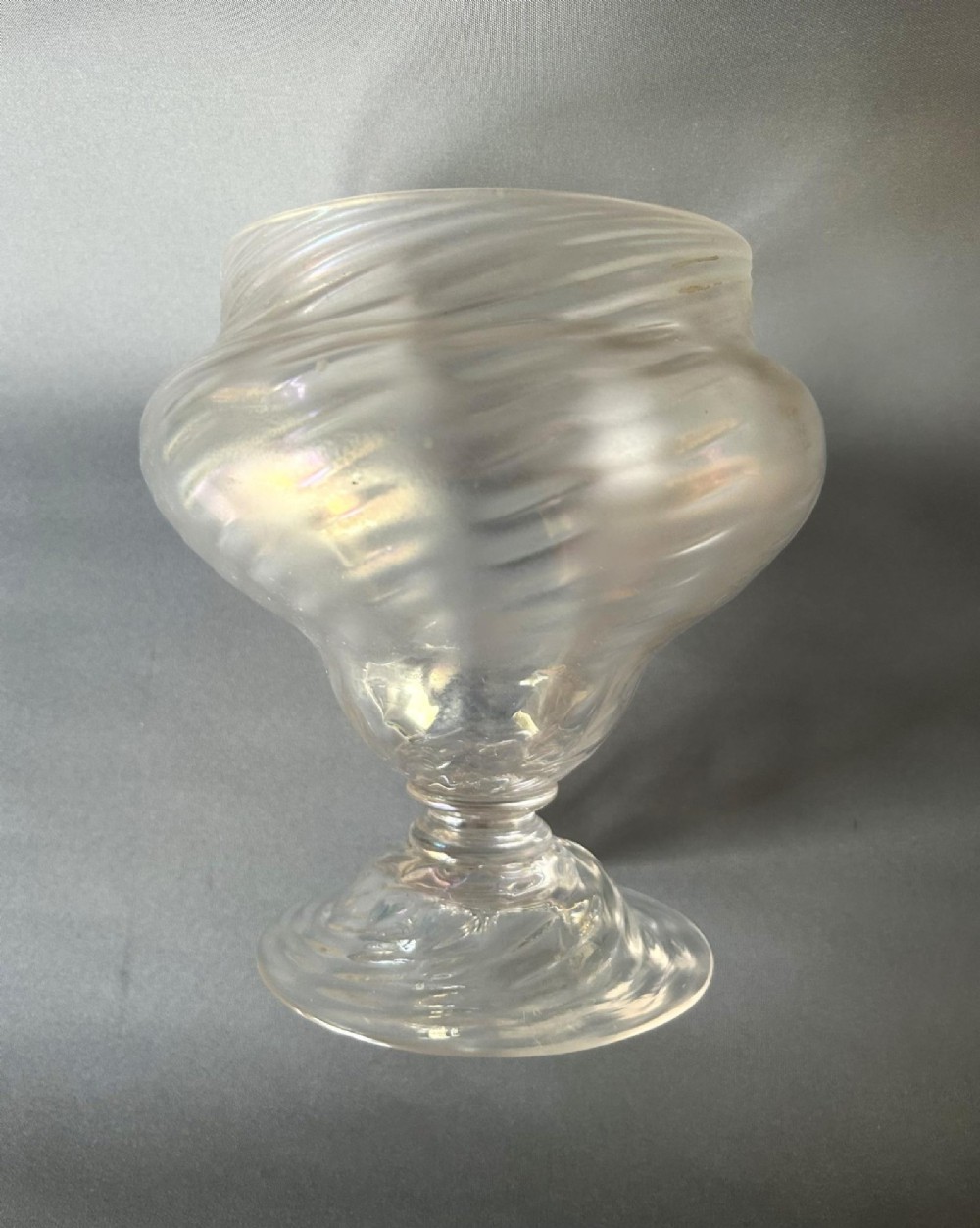 An Art Nouveau clear glass pedestal vase featuring a spiralled rib design and an iridescent lustre finish. View II