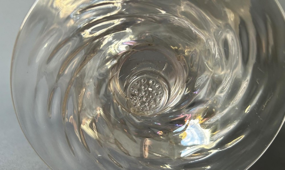 An Art Nouveau clear glass pedestal vase featuring a spiralled rib design and an iridescent lustre finish. View IV