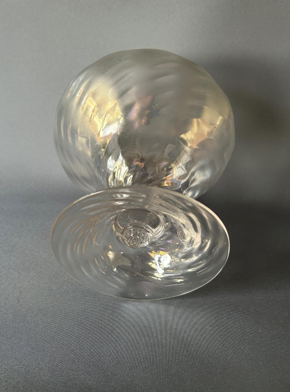 An Art Nouveau clear glass pedestal vase featuring a spiralled rib design and an iridescent lustre finish. View V