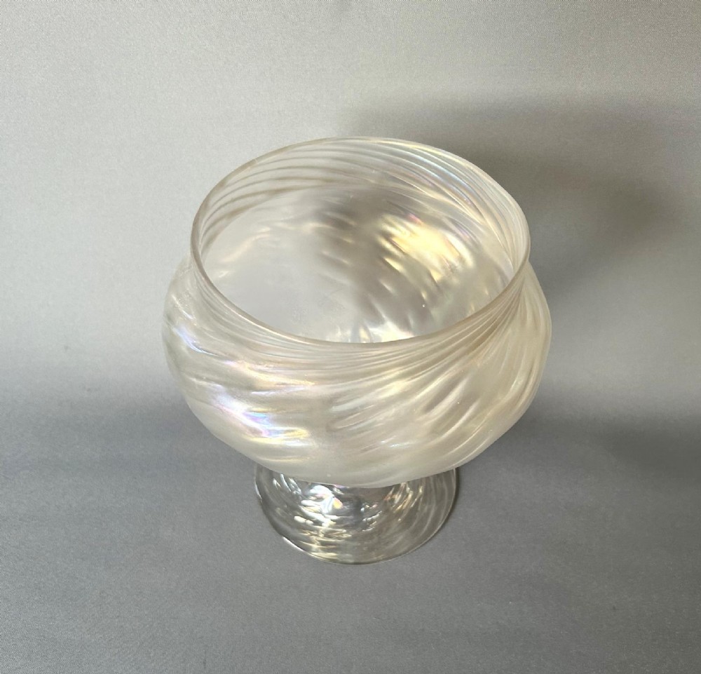 An Art Nouveau clear glass pedestal vase featuring a spiralled rib design and an iridescent lustre finish. View VII