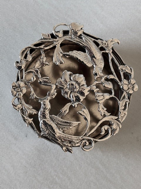 A circular Edwardian sterling silver pot pourri box with a pierced fretwork lid depicting birds and floral scrollwork. View IX