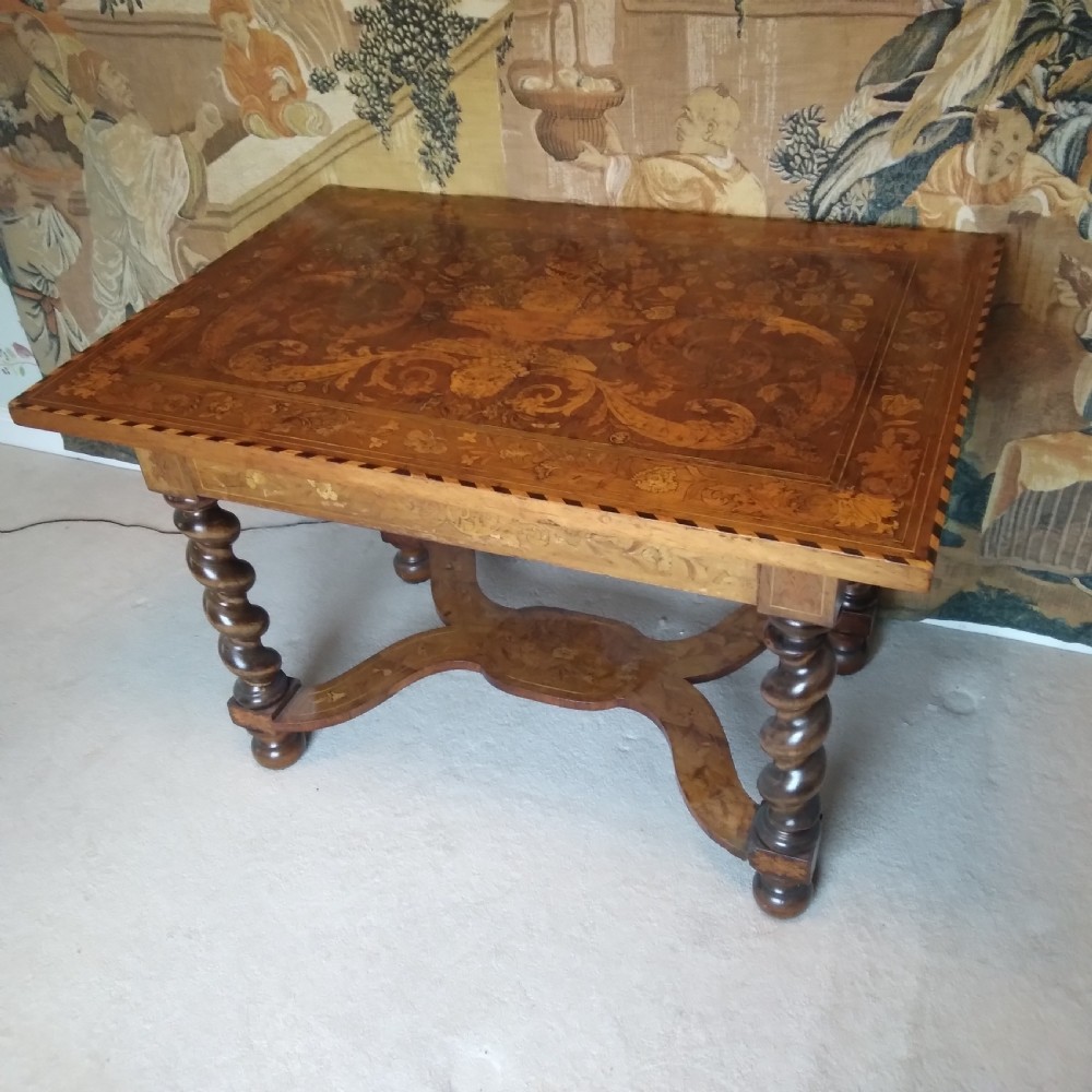 An 18th-century rectangular wooden centre table featuring elaborate floral marquetry inlay on the top, twisted legs, and a curvilinear X-frame stretcher.