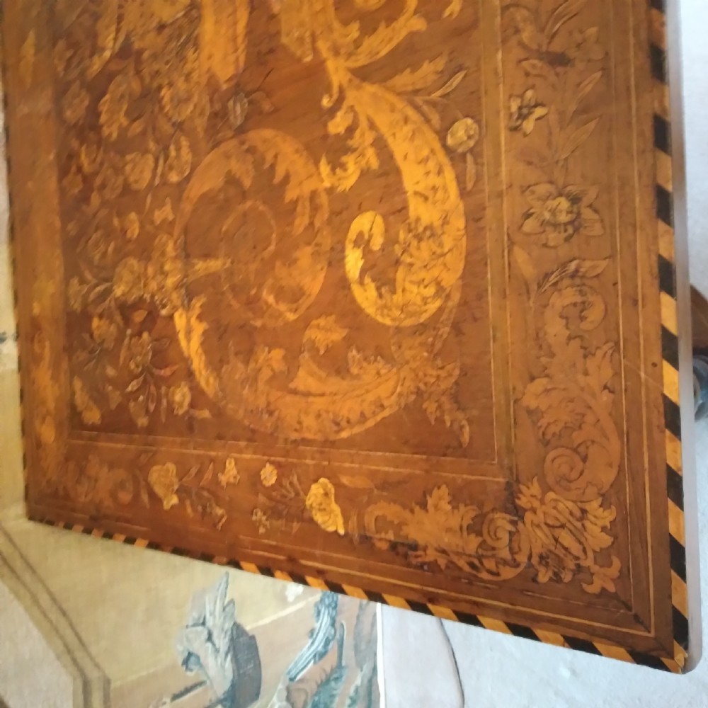 An 18th-century rectangular wooden centre table featuring elaborate floral marquetry inlay on the top, twisted legs, and a curvilinear X-frame stretcher. View XVI