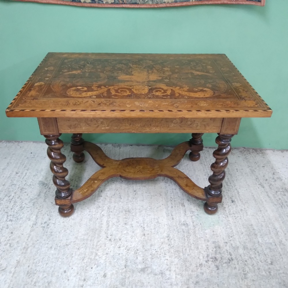 An 18th-century rectangular wooden centre table featuring elaborate floral marquetry inlay on the top, twisted legs, and a curvilinear X-frame stretcher. View XIX