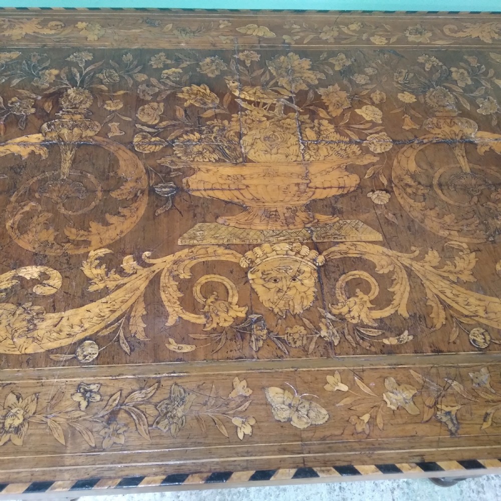An 18th-century rectangular wooden centre table featuring elaborate floral marquetry inlay on the top, twisted legs, and a curvilinear X-frame stretcher. View XXI