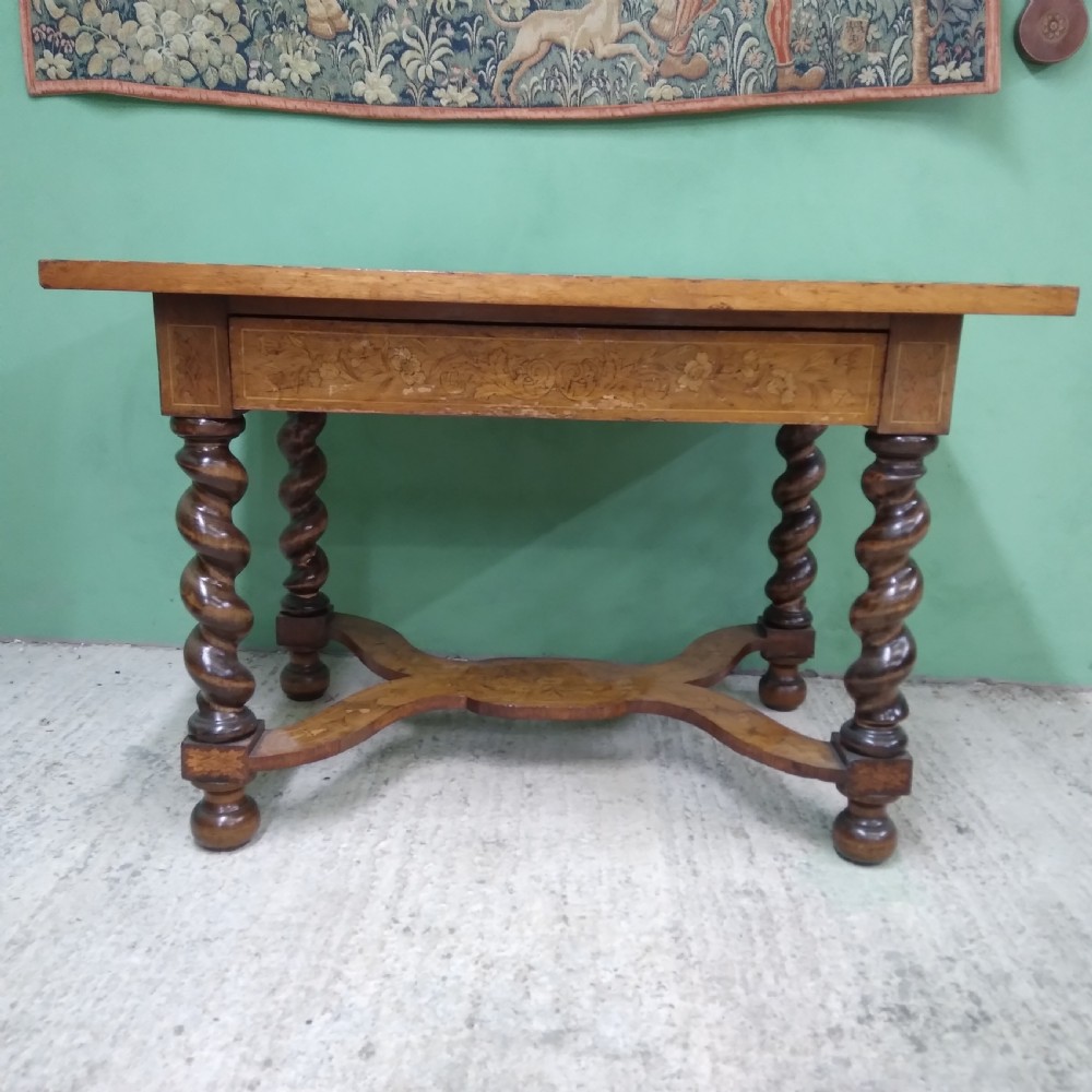 An 18th-century rectangular wooden centre table featuring elaborate floral marquetry inlay on the top, twisted legs, and a curvilinear X-frame stretcher. View XXIV