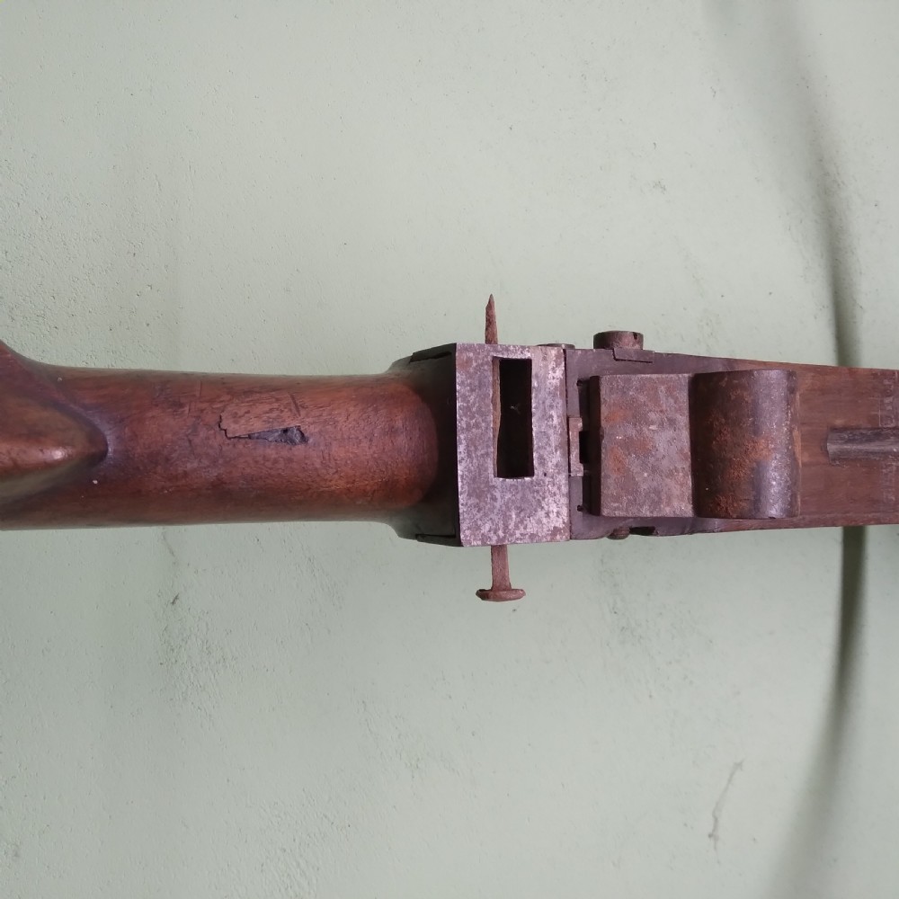 An antique wooden crossbow featuring a carved dark timber stock, a curved iron bow prod, and brass trigger embellishments. View VI