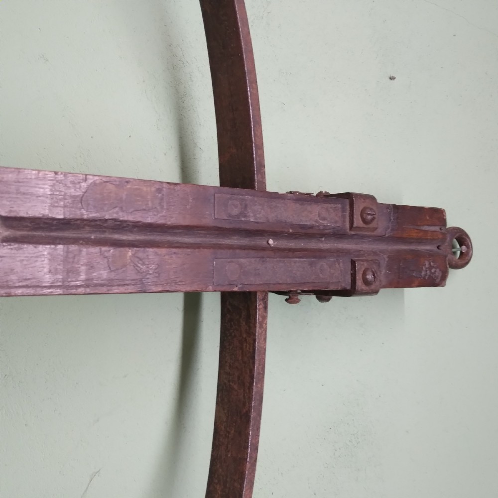 An antique wooden crossbow featuring a carved dark timber stock, a curved iron bow prod, and brass trigger embellishments. View VII
