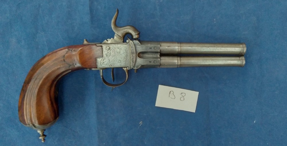 An early 19th-century revolving barrel pistol featuring twin steel barrels, an engraved lockplate, and a curved wooden grip. View III