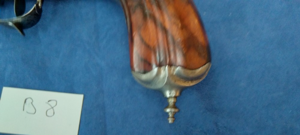 An early 19th-century revolving barrel pistol featuring twin steel barrels, an engraved lockplate, and a curved wooden grip. View VIII