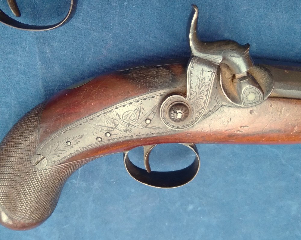 A matched pair of 19th-century percussion cap pistols featuring chequered walnut stocks, engraved steel lockplates, and brass-tipped ramrods. View III