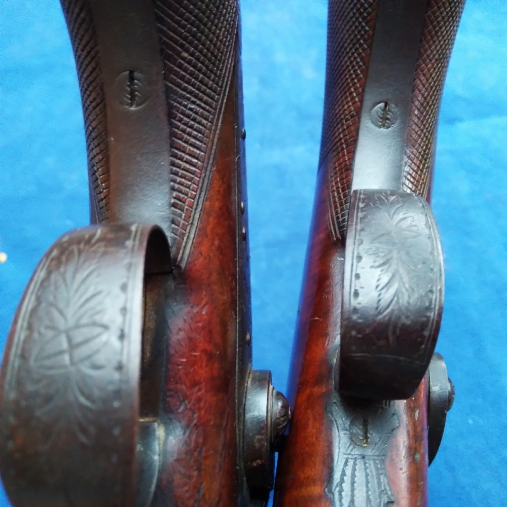 A matched pair of 19th-century percussion cap pistols featuring chequered walnut stocks, engraved steel lockplates, and brass-tipped ramrods. View IX