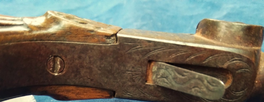 A nineteenth-century percussion cap pocket pistol with a carved walnut grip and steel barrel. View IX