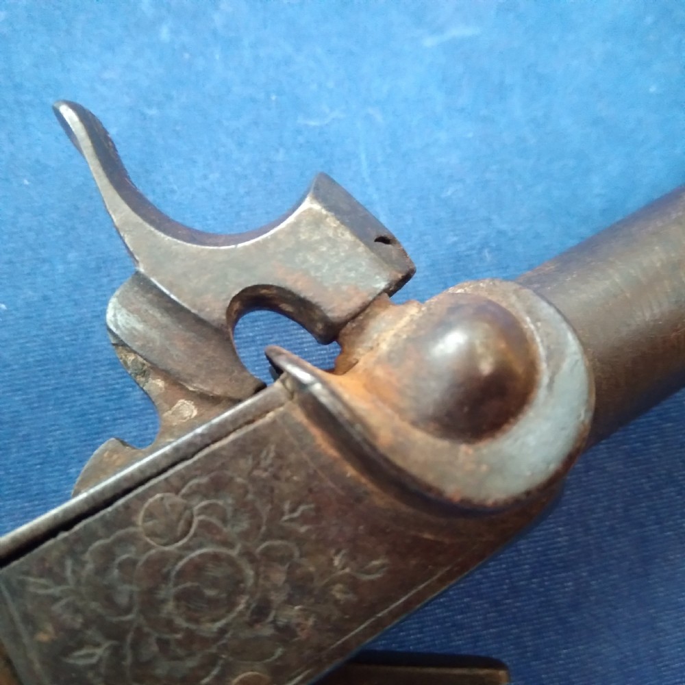 A nineteenth-century percussion cap pocket pistol with a carved walnut grip and steel barrel. View X