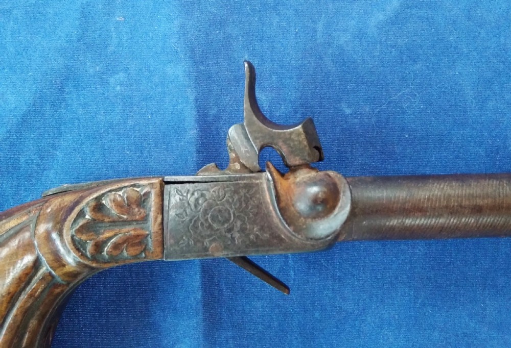A nineteenth-century percussion cap pocket pistol with a carved walnut grip and steel barrel. View III