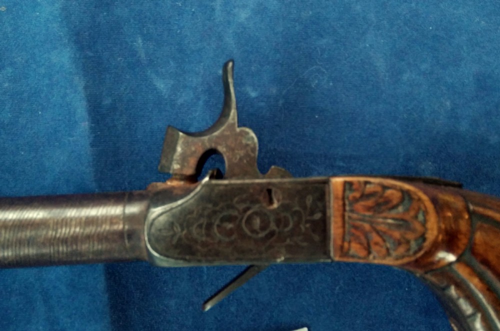 A nineteenth-century percussion cap pocket pistol with a carved walnut grip and steel barrel. View IV