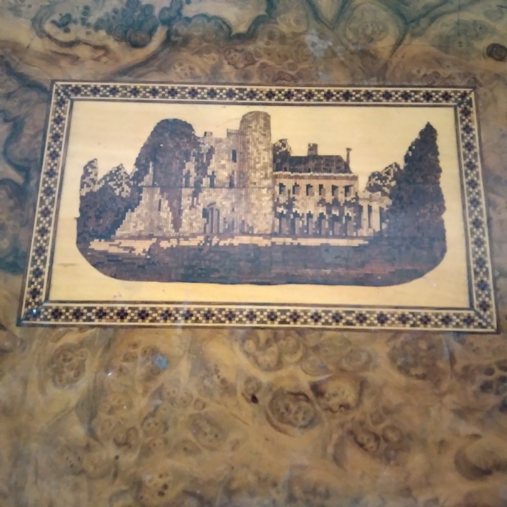 A Victorian burr walnut work table featuring a central Tunbridge ware marquetry landscape scene, serpentine edges, and turned legs with scroll feet. View III