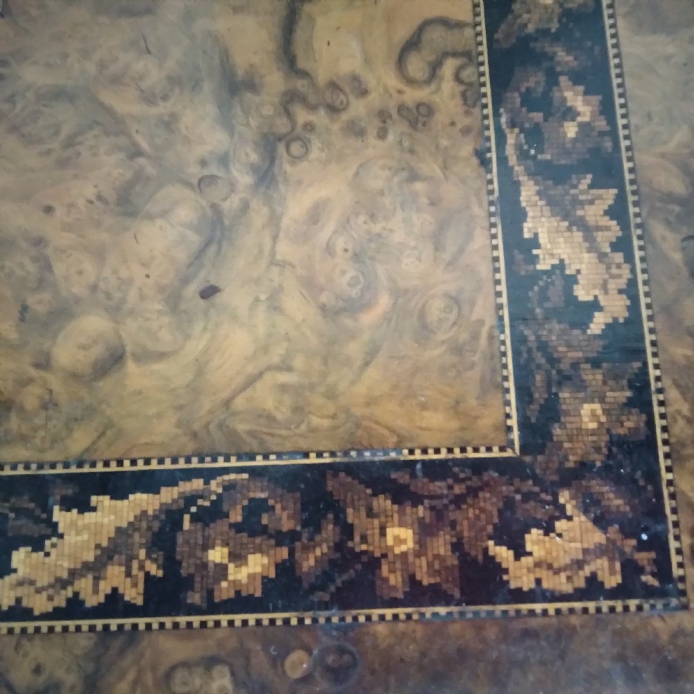A Victorian burr walnut work table featuring a central Tunbridge ware marquetry landscape scene, serpentine edges, and turned legs with scroll feet. View IV