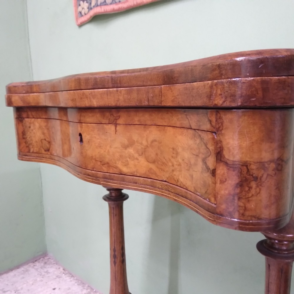 A Victorian burr walnut work table featuring a central Tunbridge ware marquetry landscape scene, serpentine edges, and turned legs with scroll feet. View VII